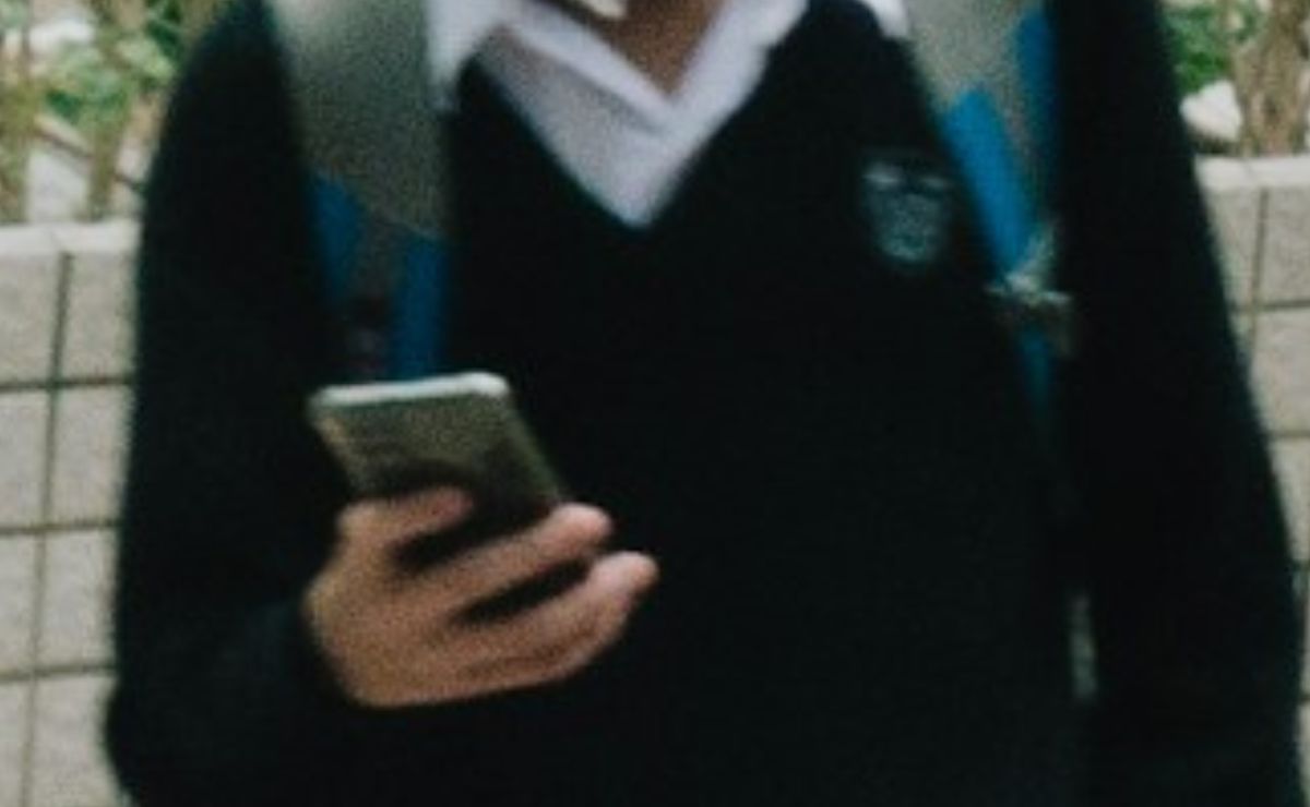 alumno-de-educacion-basica-con-un-telefono-celular-en-la-mano